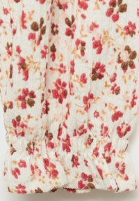 Floral fabric with small pink and brown flowers on a cream background. Texture is crinkled; gathered cuff detail at the bottom.