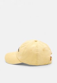 Gul bomulls-baseballkeps med en böjd skärm, med en svart logotyp på framsidan och ett justerbart band på baksidan. Mjuk textur, avslappnad design.