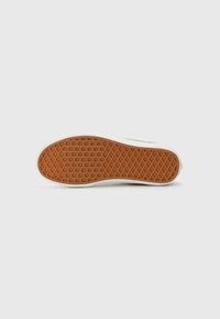 Rubber shoe sole with a textured, honeycomb pattern in orange. Features a white edge and smooth finish around the perimeter.