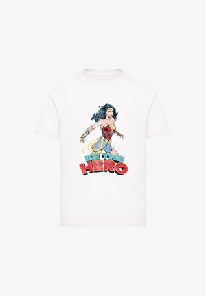 Weißes Baumwoll-T-Shirt mit einem bunten Wonder Woman-Graphic und dem Text "SEI DER HELD" in fettem Rot und Blau. Kurzarm und Rundhalskragen.