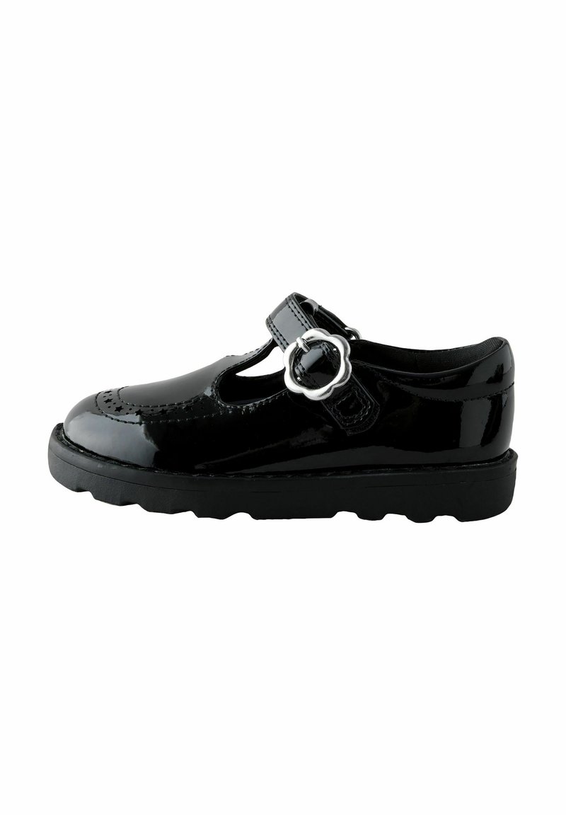 Chaussure Mary Jane en cuir verni noir avec un bout rond, des détails perforés, une sangle à boucle réglable et une semelle en caoutchouc texturée.