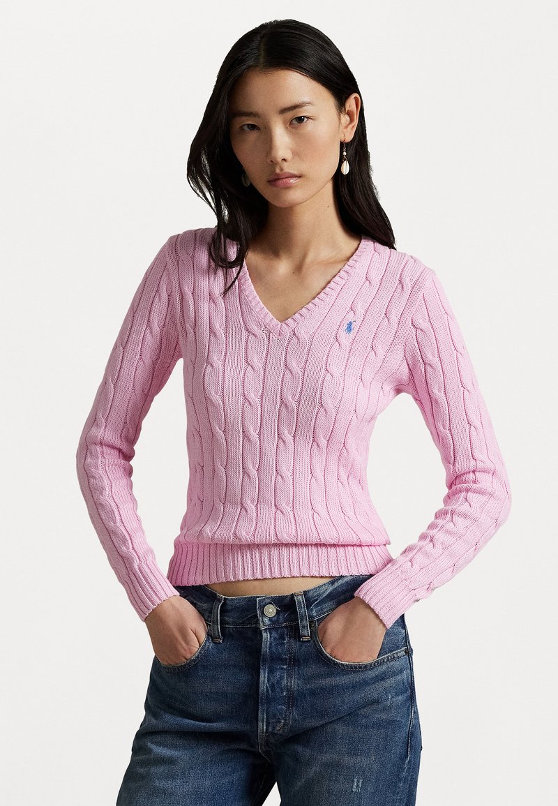 Pink cable-knit sweater with a v-neck and long sleeves, featuring a ribbed hem and a small logo accent on the chest.