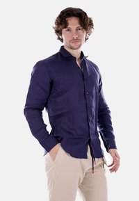 Camicia a maniche lunghe blu navy in tessuto leggero con colletto button-down e bottoni frontali; presenta polsi dettagliati e una vestibilità slim.