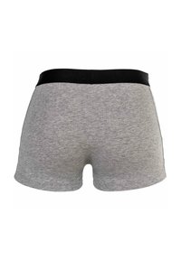 Graue Baumwollshorts mit einem schwarzen elastischen Bund, die eine glatte Textur und ein einfaches Design aufweisen, ohne sichtbare Muster oder Akzente.