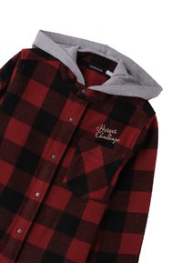 Chemise à carreaux rouge et noir avec capuche grise, poche avant et broderie "Heroes Challenge" sur la poitrine.