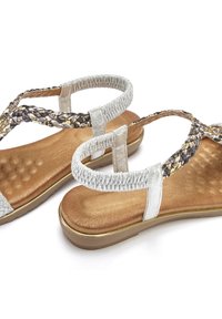 Geflochtene Sandalen mit einem silbernen Riemen, einem strukturierten Fußbett in Gold und Braun, einer gepolsterten Sohle und einer Gummisohle. Verstellbares elastisches Detail an der Ferse.