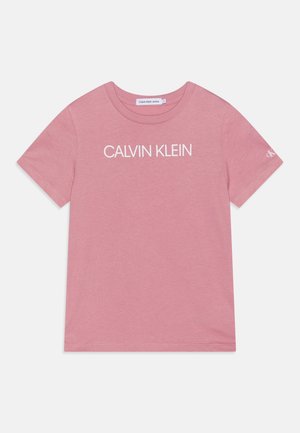 Pink T-shirt med korte ærmer med "CALVIN KLEIN" trykt hvidt på forsiden og et lille "ck" logo på venstre ærme.