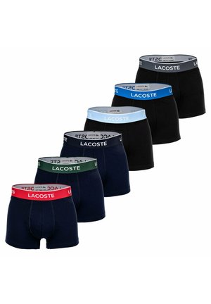Vijf paar Lacoste herenboxershorts, die om en om zwart en marineblauw zijn, met gebrandmerkte taillebanden in rood, groen, marineblauw, lichtblauw en grijs.