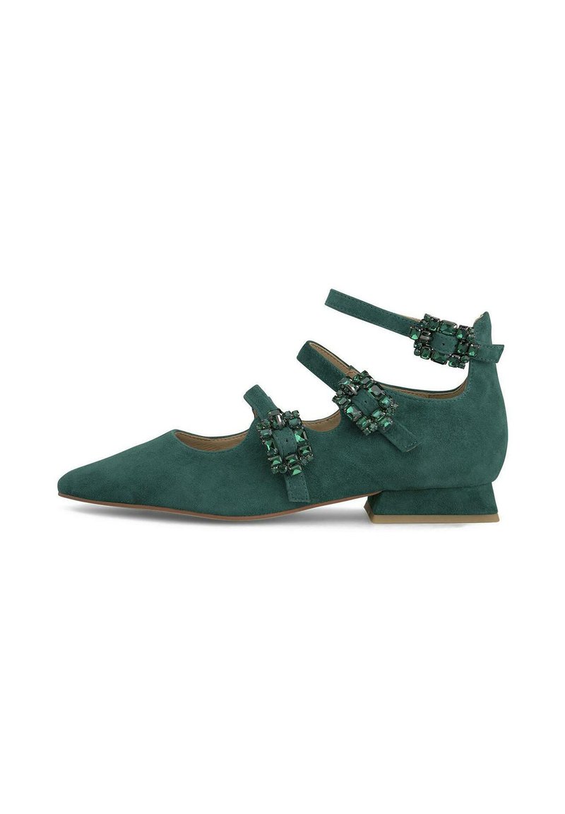 Zapato de gamuza verde, con punta afilada y tacón bajo en bloque. Presenta tres correas con acentos decorativos de piedras preciosas verdes. Textura suave.