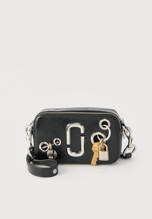 Czarna prostokątna skórzana torba na ramię z srebrnymi okuciami, dużym metalowym logo, brelokami w kształcie klucza i kłódki na froncie oraz paskiem na nadgarstek.