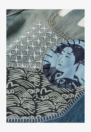 Tessuto in denim con stelle bianche ricamate, una toppa con motivo astratto in bianco e nero e una toppa circolare cucita con il volto di una donna.