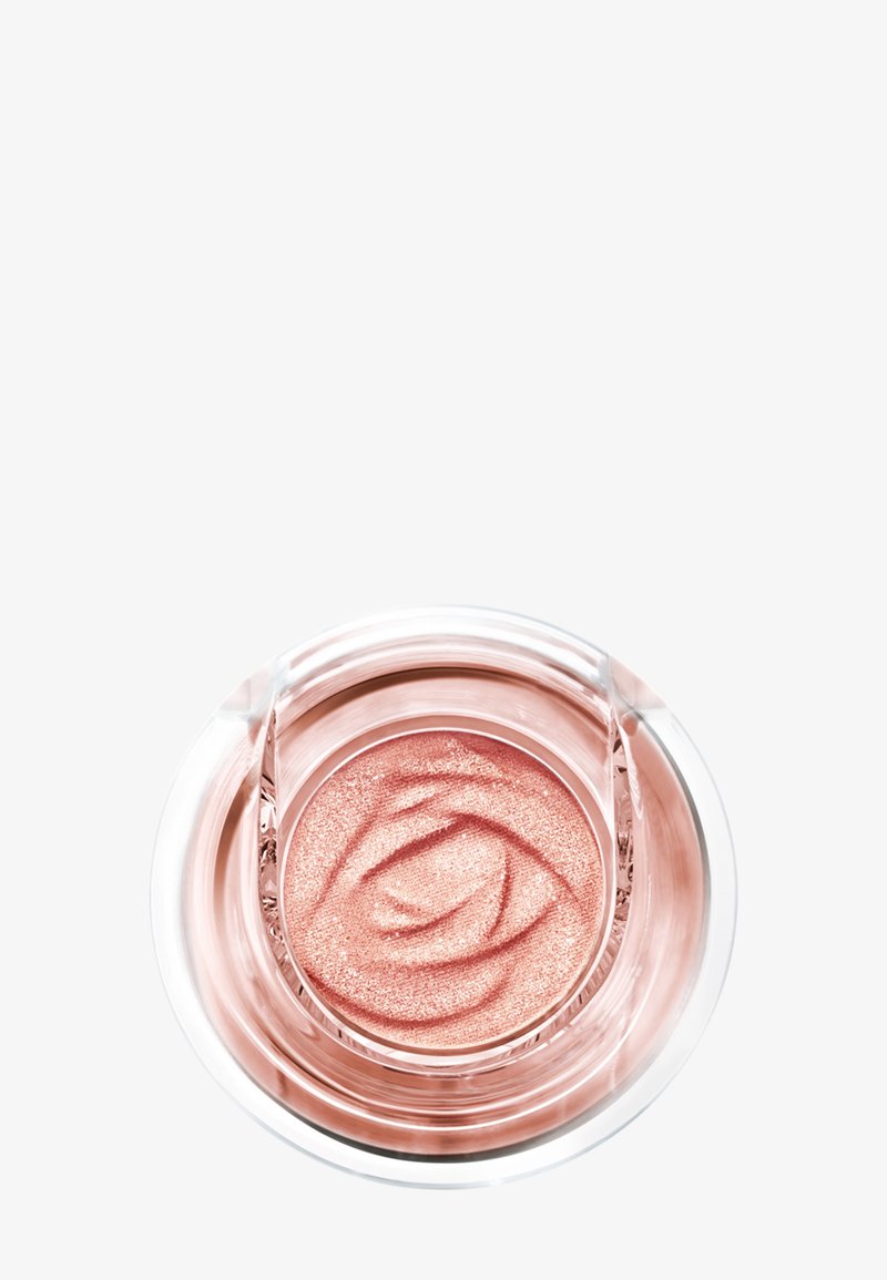 Blush crème rose scintillant sculpté avec un motif en spirale en relief à l'intérieur d'un pot rond transparent sur un fond blanc.