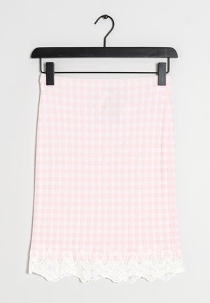 Rosa og hvid ternet nederdel med blonder ved kanten, hængende på en sort klemmebøjle mod en ensfarvet baggrund.