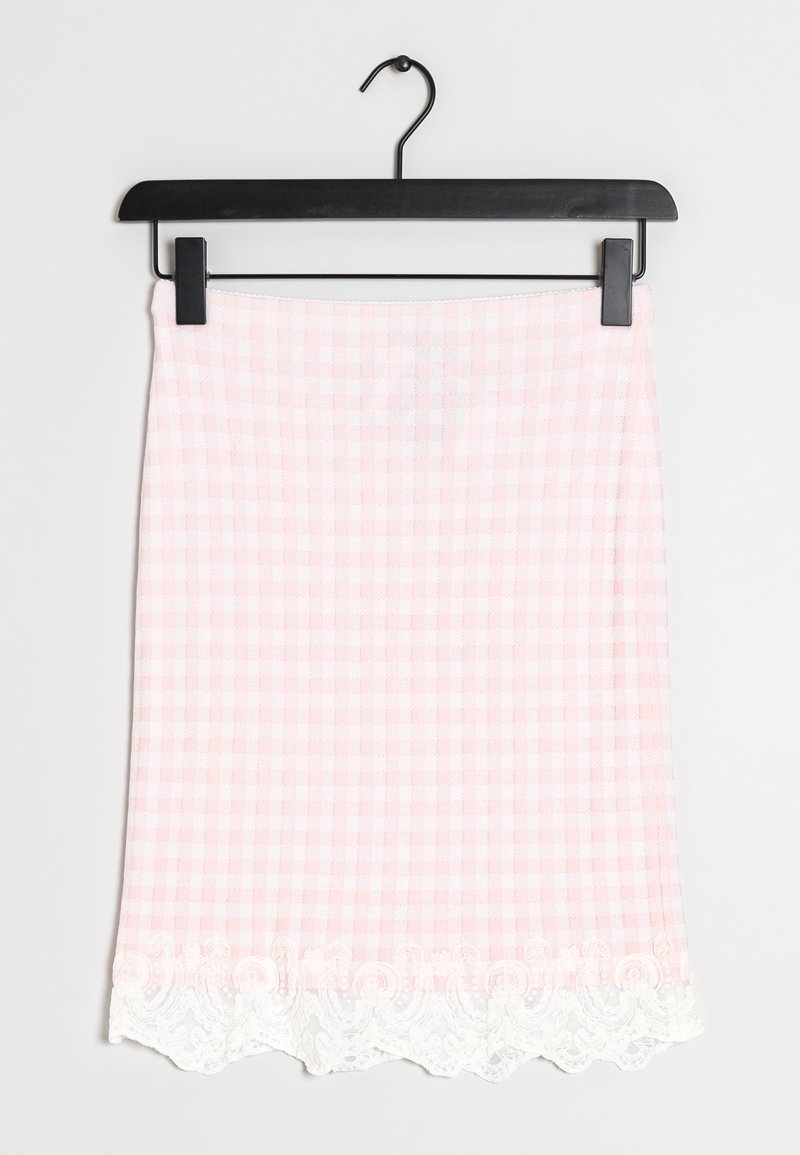 Jupe à carreaux rose et blanc avec bordure en dentelle à l'ourlet, suspendue sur un cintre noir à pinces sur un fond uni.