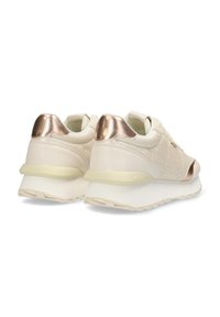 Béžové tenisky s texturovaným svrškem, kovovými zlatými detaily na patě a masivní bílou podrážkou. Hladký materiál a moderní design.