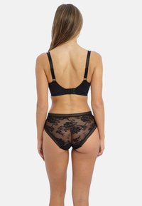 Ensemble de lingerie en dentelle noire comprenant un soutien-gorge à fermeture au dos et une culotte haute assortie, ornée d'un motif floral et d'une texture transparente.