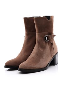 Bruna mockaskinnankelboots med spetsig tå, en medelhög klack och en sidobuckla. Slät struktur med en ren silhuett.