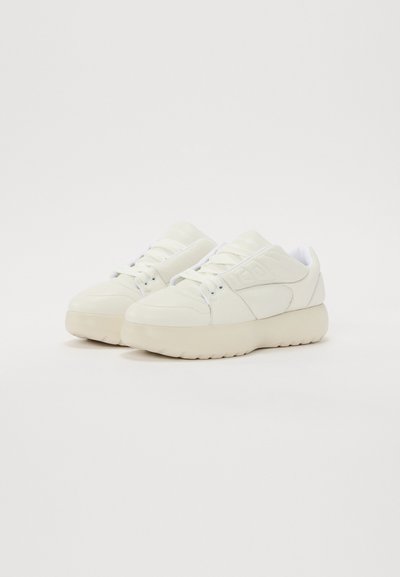 Baskets blanches en cuir avec une semelle épaisse et texturée, un embout arrondi et une languette rembourrée. Présente des coutures ton sur ton et un branding minimal.