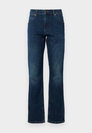 Blå denim flared jeans har en mid-rise talje, fem lommer og et diskret falmet mønster på benene. Lukningen har en metalknap.