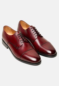 Bordeaux leren dresschoenen met een gepolijste afwerking, cap toe ontwerp en zwarte veters. Beschikken over een soepele textuur en een stevige zwarte zool.