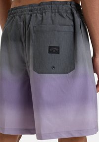 Pilkos ir purpuros spalvos gradientiniai maudymosi šortai, su elastinga juosta, galiniu kišeniu ir logotipo etikete ant galinio kišenio.