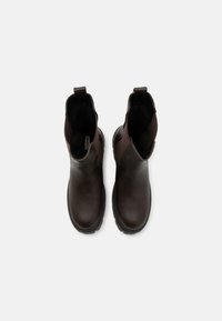 Bottines en cuir marron avec un bout rond, des panneaux latéraux élastiques et des tirants. Des semelles en caoutchouc texturé garantissent une bonne adhérence.