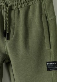 Groene sweatpants van zachte stof, met een elastische tailleband, gevlochten trekkoord, zijzakken en een zwart label.