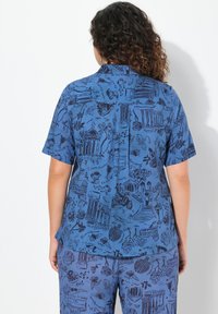Camisa azul de manga corta con un patrón repetido de ilustraciones de arquitectura clásica y naturaleza, hecha de una tela ligera.