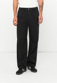 Svart bomulls wide-leg bukser med elastisk midje og frontknapp. Har sidelommer og en jevn tekstur.