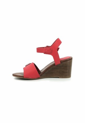 Sandalo wedge rosso con un tacco in legno marrone texturizzato, caratterizzato da una ampia cinghia sulla punta e un accento con fibbia sulla cinghia anteriore. Cinghia alla caviglia regolabile.