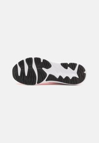 Semelle de chaussure de sport en noir et blanc présentant un motif de grip texturé et des crêtes en caoutchouc uniques. Transition fluide du noir au blanc.