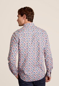 Bloemige overhemd met knopen, met een pastelroze achtergrond en blauwe, groene en oranje designs; lange mouwen met ronde manchetten.