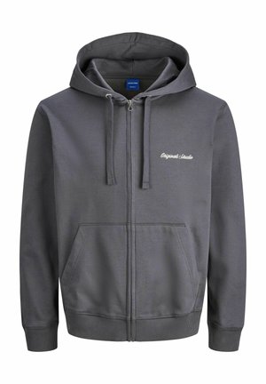 Hallide pruun kapuutsiga sulejope, millel on köiejope, ees olevad taskud ja soonikkoes mansetid. Rinnal on tikandkirjad. Sile tekstuur.