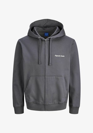 Hallide pruun kapuutsiga sulejope, millel on köiejope, ees olevad taskud ja soonikkoes mansetid. Rinnal on tikandkirjad. Sile tekstuur.