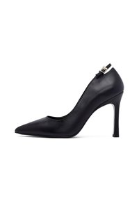 Zapatos de tacón alto de punta afilada en cuero negro con tiras al tobillo y hebilla dorada, diseño elegante y sofisticado, aislados sobre fondo blanco.
