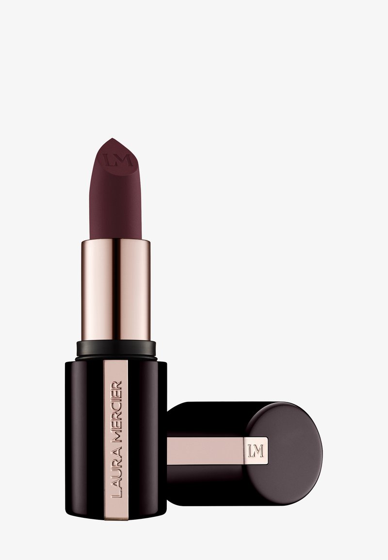 Leppestift i en mørk mauve farge, matt finish og med en spiss tupp. Beholderen har en svart bunn med gullkant og logo.