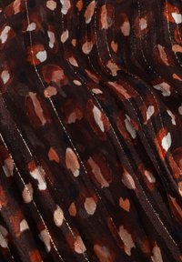Bruine doorschijnende stof met een verspreid abstract patroon in verbrande oranje en crème, met fijne metallic gouden strepen voor extra textuur.