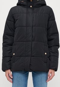 Svart puffjacka med huva, med horisontella quiltade sektioner, detaljer i guldton och sidofickor. Slät, lätt tyg.