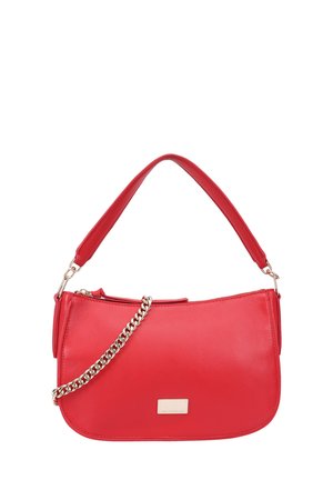 Sac à main en faux cuir rouge avec une forme incurvée, doté d'une bandoulière à chaîne détachable, d'une texture lisse et d'une petite plaque métallique de la marque.