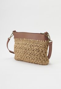 Clutch in stile intrecciato di paglia con accenti in pelle marrone testurizzata, dotata di chiusura a zip e di una tracolla rimovibile.