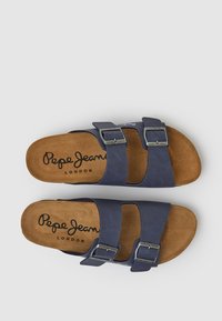 Tumši zili sandales ar diviem regulējamiem siksniņām, sudraba sprādzēm un brūnu zamša zolīti, uz kuras ir zīmols "Pepe Jeans London".