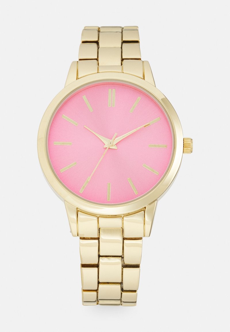 Montre-bracelet en métal doré avec un cadran rose, des index dorés et trois aiguilles dorées indiquant 10:10:36.