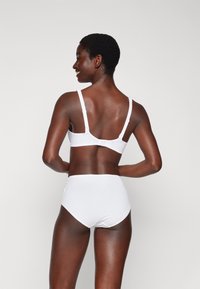 White bra and high-waisted bikini bottom, made of smooth fabric, featuring adjustable straps and a hook closure at the back.