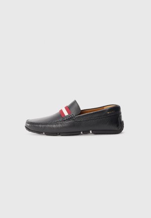 Chaussure noire en cuir à enfiler avec surface texturée, accent rayé rouge et blanc sur le dessus, bout rond et semelle en caoutchouc.
