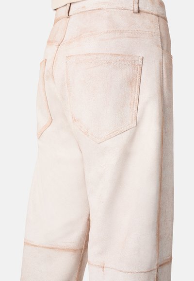 Light beige pants with a textured, suede-like fabric. Features two back pockets with visible stitching accents and a relaxed fit.