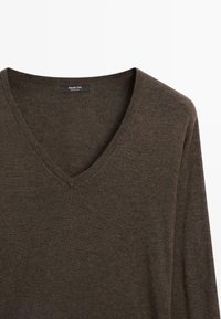 Brown V-neck sweater made of soft knit material with long sleeves; features a label on the neckline. Simple, unadorned design.