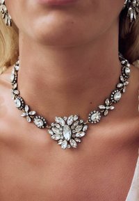 Kristallhalskette mit einem filigranen Blumendesign, das aus Marquise- und runden Steinen besteht, in einer dunklen Metallfassung.