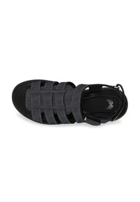 Black sandal with woven straps made of denim material. Features an adjustable ankle strap and a textured sole.