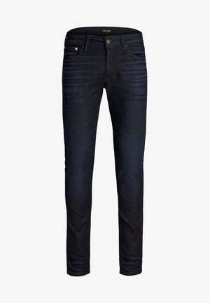 Vaqueros ajustados para hombre de color azul oscuro con bolsillos delanteros, cierre de botón, ligeras marcas de desgaste en los muslos y etiqueta de la marca en la cintura.