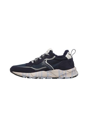 Dunkelblauer und weißer Sportschuh mit grauen Schnürsenkeln, dicker Sohle und Zuglasche an der Ferse, seitlich auf weißem Hintergrund gezeigt.